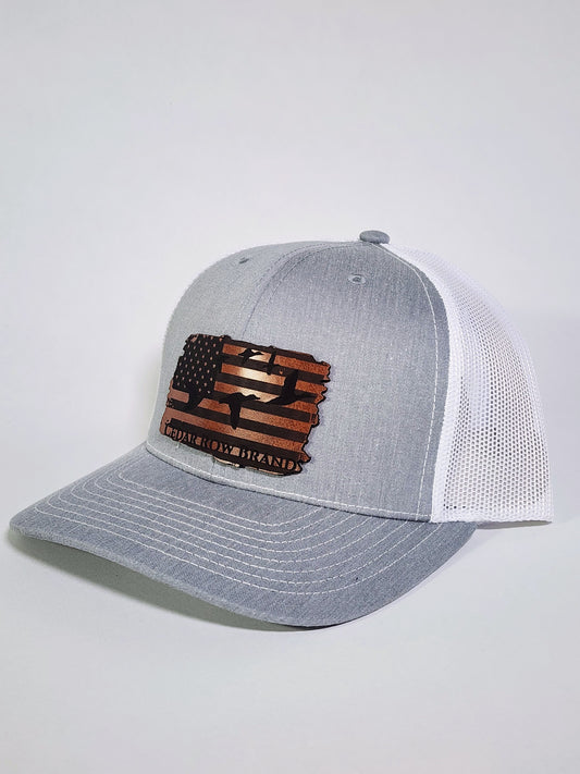 cedar row brand leather patch with ducks flying across american flag  on a gray trucker hat